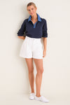 Young woman models the Denim Collar Carlyn Long Sleeve Polo, showcasing its classic, effortless design with a playful denim collar and relaxed fit.