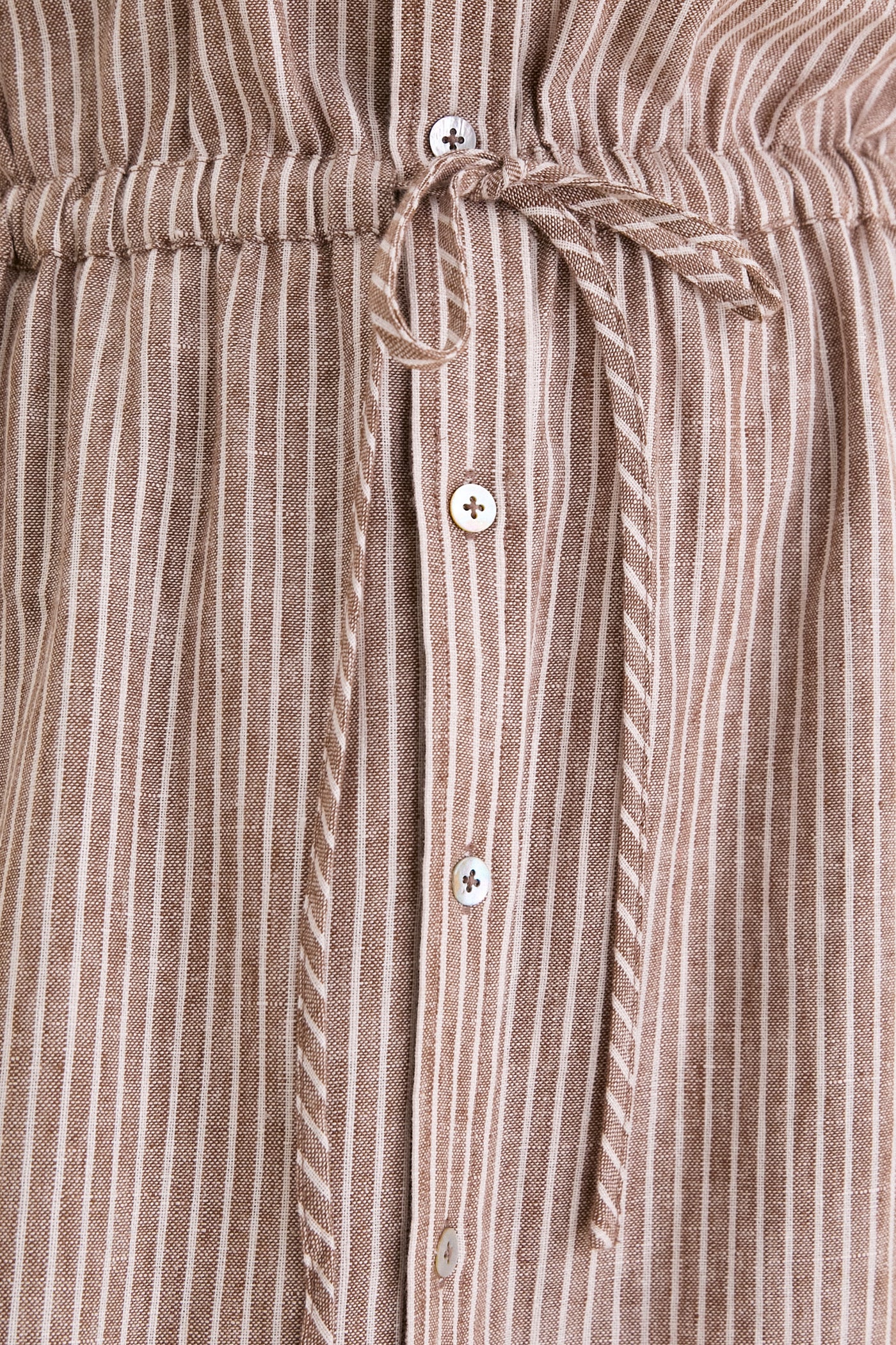 Close-up of Cafe Stripe Linen Julien Shirt Dress, showcasing its classic, high-end design with gathered waistband, button front, and effortless drawstring bow detail.
