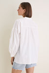 White Shadow Stripe Juliette Button Down with flowy silhouette, gathered sleeves, and asymmetrical hem, worn with denim shorts. Effortless classic style for a fun, high-end look.