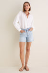 White Shadow Stripe Juliette Button Down: A classic, effortless blouse with subtle stripes and gathered sleeves, paired with high-rise denim shorts for a fun, high-end casual look.