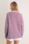 Back view of a person in the All-Star Stripe Clark Sweater, a classic, effortlessly cool top with red and white stripes, exuding high-end, fun style.