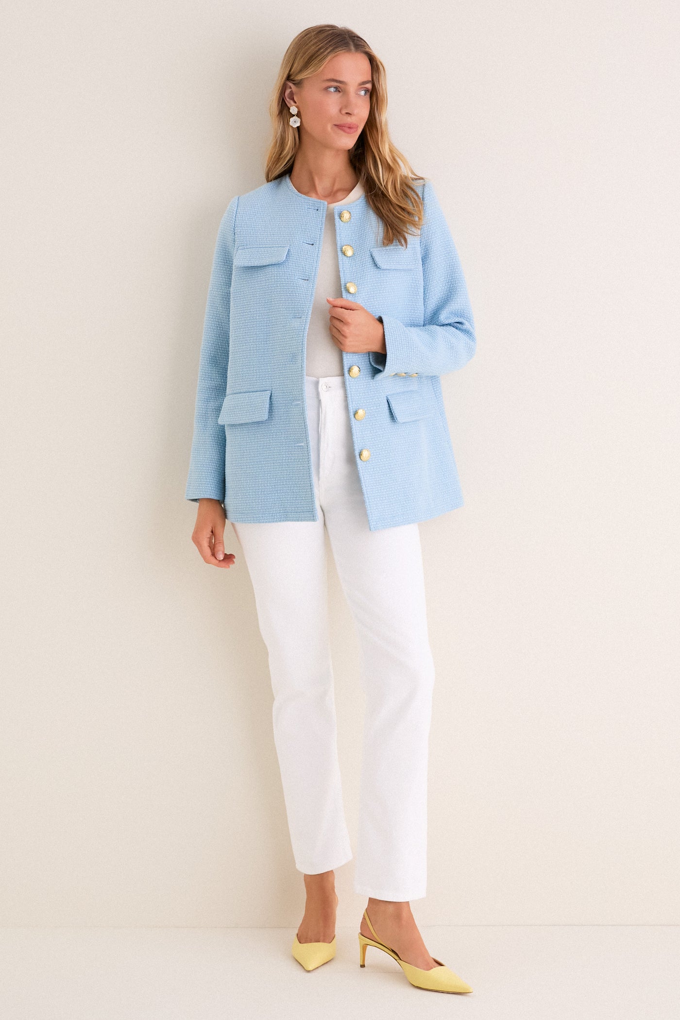 Model wearing a classic Light Blue Tweed Jennings Jacket with gold buttons, styled effortlessly over a white top and jeans, paired with fun yellow heels.