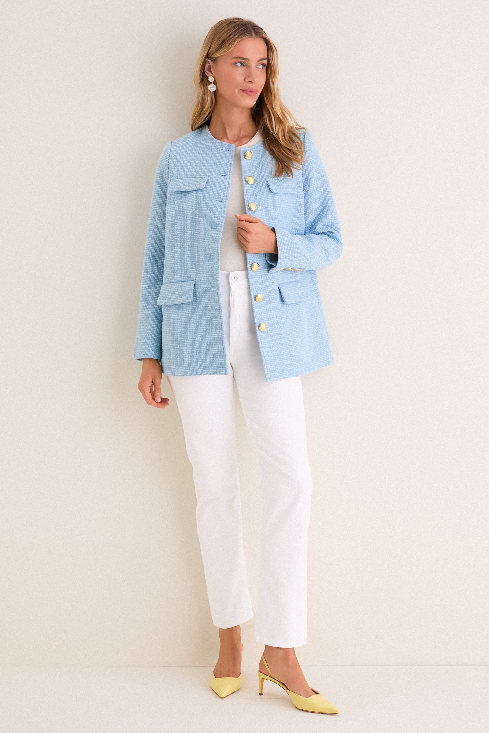Model wearing a classic Light Blue Tweed Jennings Jacket with gold buttons, styled effortlessly over a white top and jeans, paired with fun yellow heels.