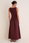 Back view of a model in a classic Dark Cherry Boatneck Mix Media Midi Dress, showcasing its effortless silhouette and gathered maxi-length skirt, styled with fun, high-end flair.