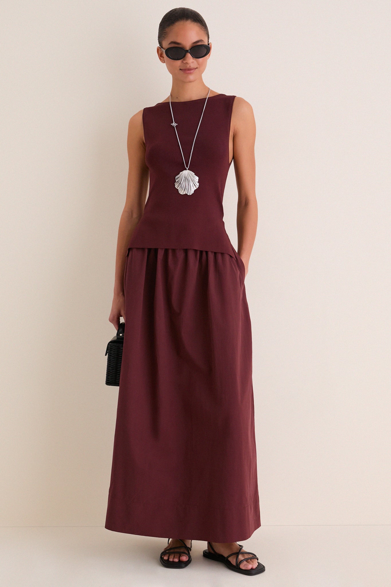 Fashion model in a classic Dark Cherry Boatneck Mix Media Midi Dress with effortless style, showcasing a sleek silhouette, side pockets, and a fun shell pendant necklace.