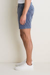 Person wearing classic Faded Navy Saturday Corduroy Shorts, featuring an elastic drawstring waist and hidden zipper pocket, styled effortlessly with white sneakers.