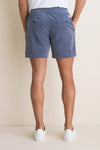Back view of a person wearing classic, effortless Faded Navy Saturday Corduroy Shorts with button-flap pockets, paired with white sneakers. High-end, fun, and comfortable summer style.