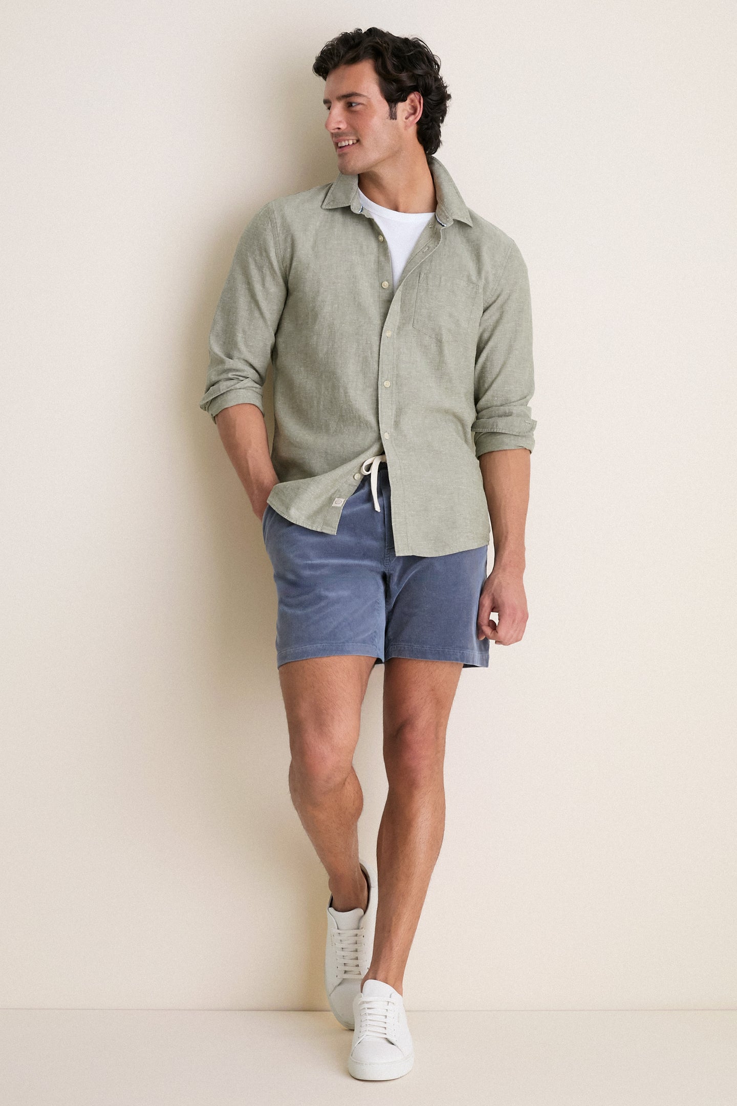 Man in classic, effortless Faded Navy Saturday Corduroy Short with elastic drawstring waist and pockets, exuding a fun, high-end vibe.