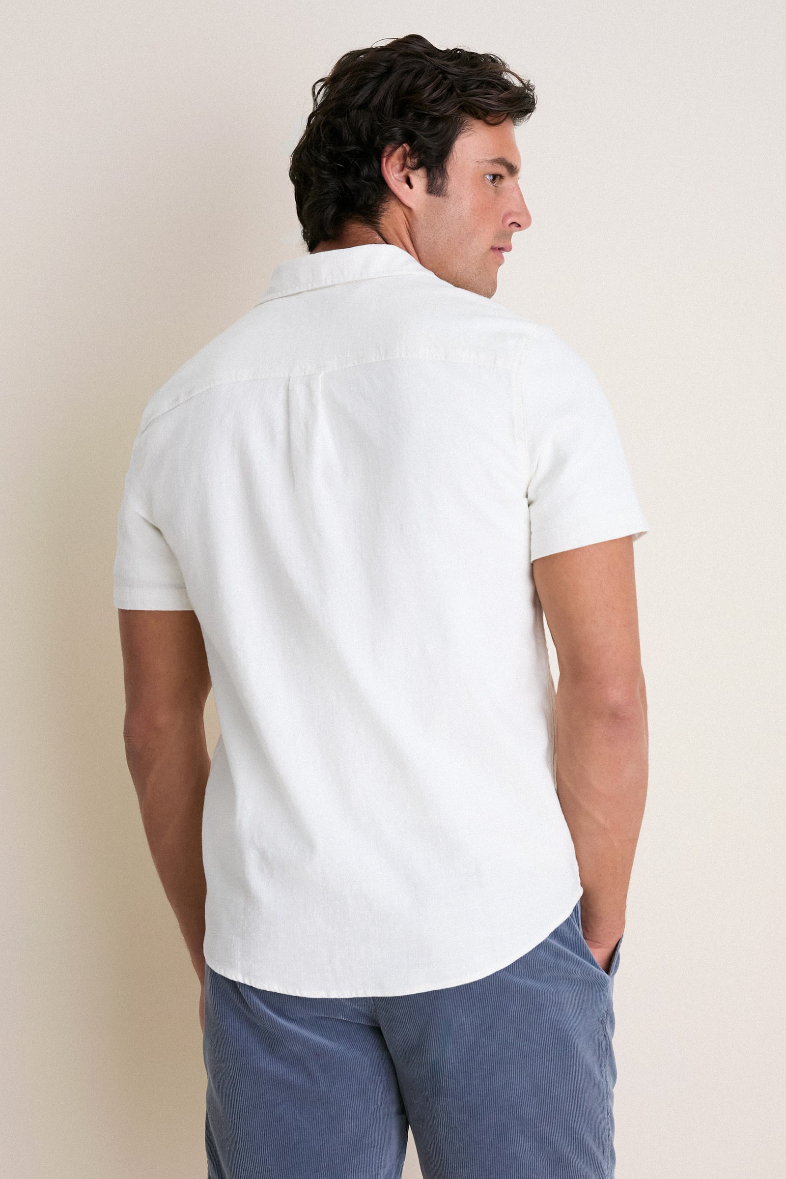 Man in profile wearing the White Classic Stretch Selvage Shirt by Marine Layer, exuding an effortless, high-end style. The shirt's classic fit and added stretch ensure comfort and fun.