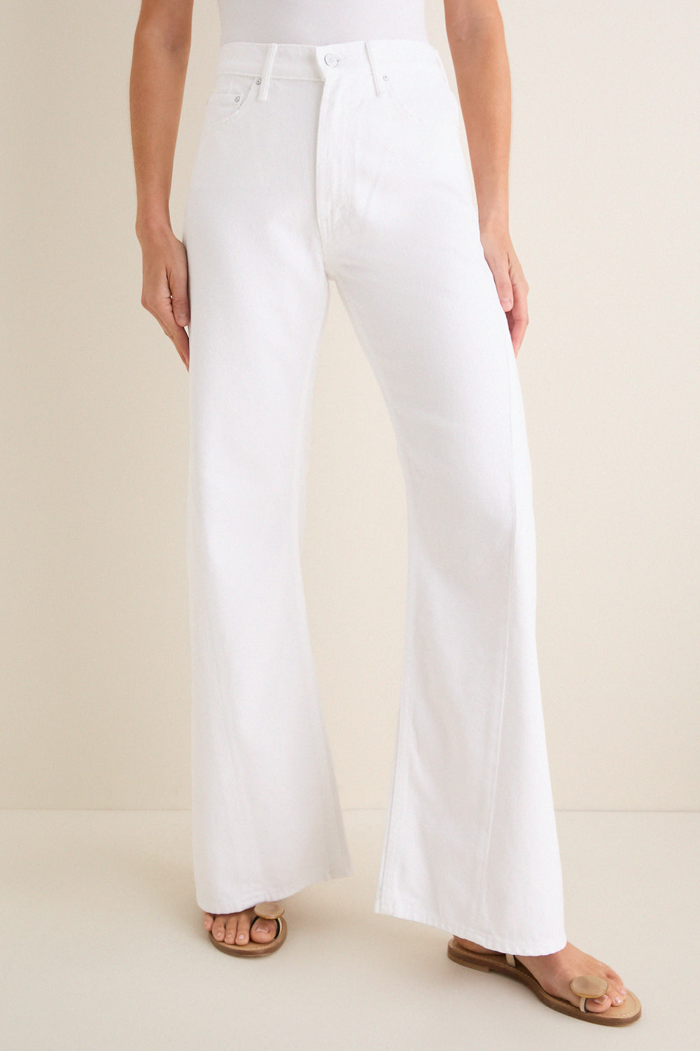 Person wearing Pinch of Salt The Lemon Twist Skimp high-waisted, wide-leg jeans with tan flat sandals, exuding a classic, effortless style on a neutral backdrop.