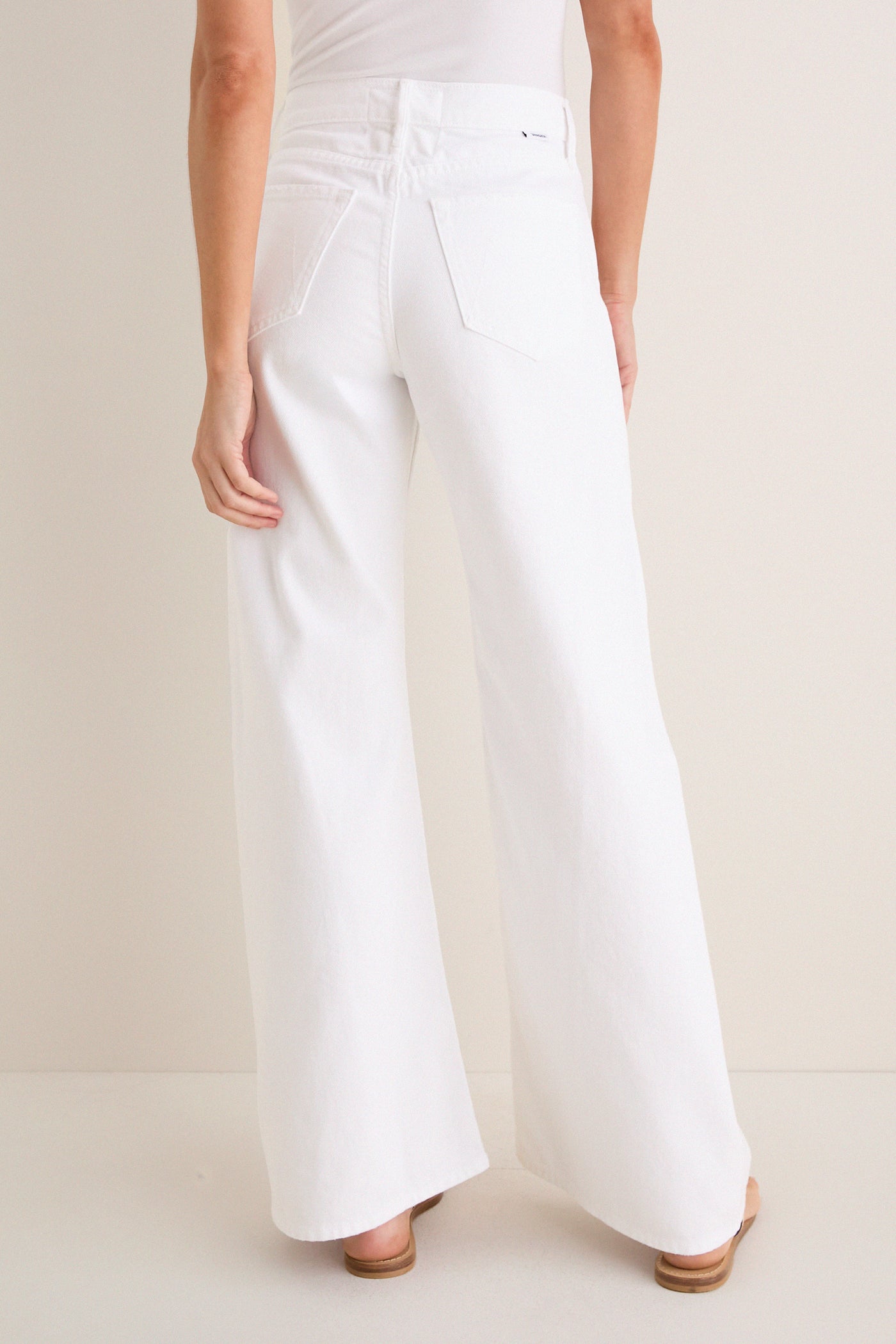 Back view of Pinch of Salt The Lemon Twist Skimp, featuring high-waisted, wide-leg white pants with rear pockets, embodying a classic, effortless style with high-end appeal.