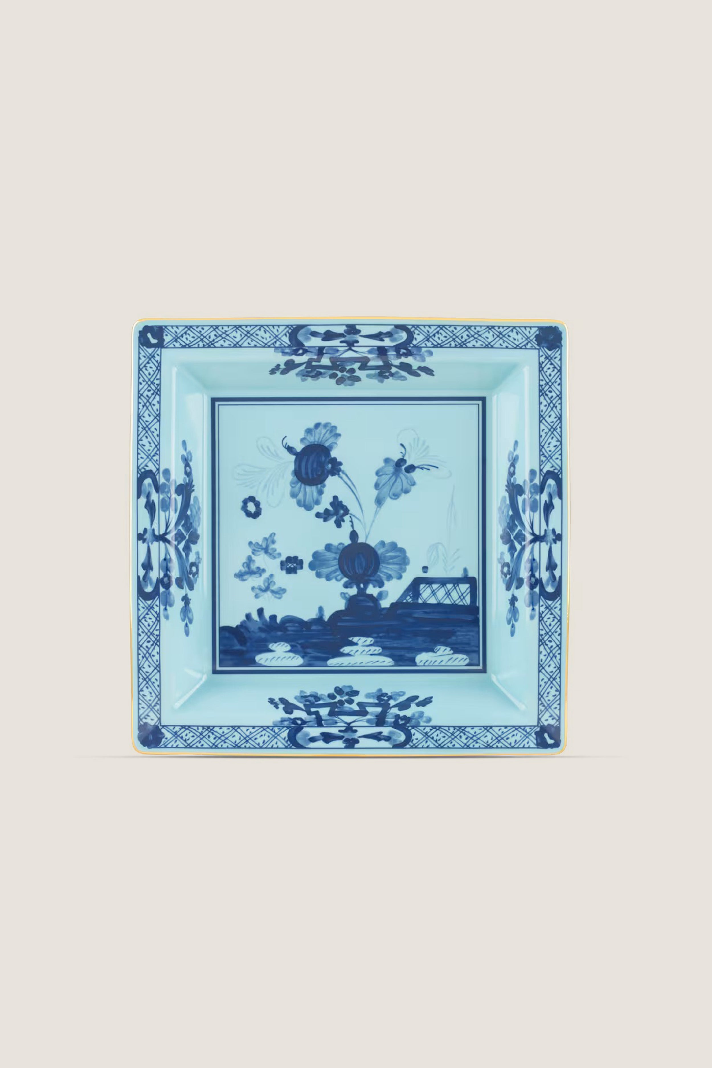 Oriente Italiano Iris Large Square Change Tray: A classic porcelain dish featuring a blue carnation motif, gold trim, and geometric border for an effortless, high-end touch.