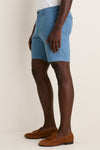 Person wearing Storm Andrews Flat-Front Short, showcasing classic, tailored light blue shorts with brown suede loafers. Effortless, high-end style for fun, warm-weather adventures.