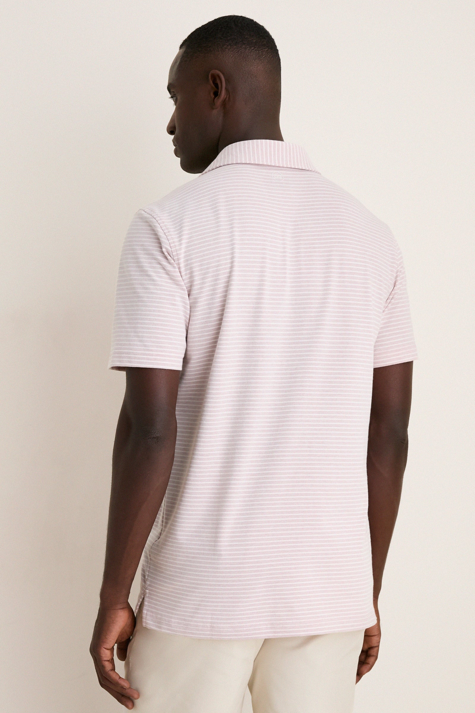 Back view of a man wearing the Faded Scarlet Stripe Albatross Cotton Blend Pique Polo, showcasing its classic design and effortless elegance with a high-end finish.