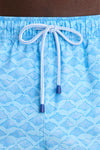 Close-up of Crystal Sea Coronado Swim Trunk showcasing light blue fabric with manta-ray pattern, elastic waist, and white drawstring, embodying Tuckernuck's effortless, high-end style.