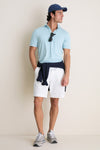 Man wearing the Light Willow Ballad Performance Jersey Polo, showcasing its classic style and effortless fit. He embodies a high-end, fun look with tailored shorts and accessories.