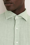 Close-up of a person wearing the Grandview Shoreside Linen Sports Shirt, a classic, effortless high-end button-down with a button-down collar, perfect for a fun, confident look.