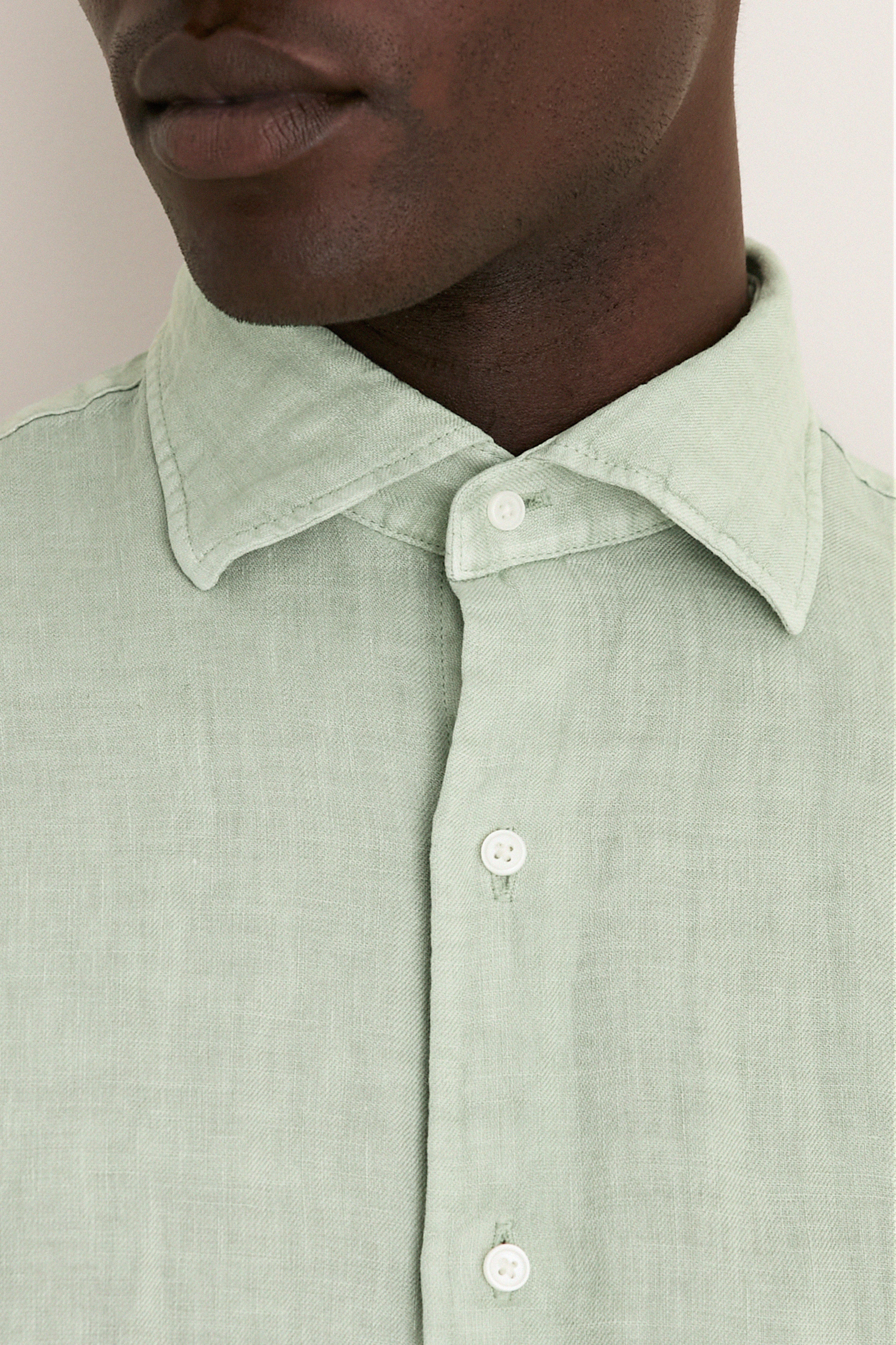 Close-up of a person wearing the Grandview Shoreside Linen Sports Shirt, a classic, effortless high-end button-down with a button-down collar, perfect for a fun, confident look.