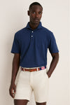 Young man models the Navy Ryles Crown Flex Cotton Polo, showcasing its classic cutaway collar and effortless, high-end style, paired with beige chino shorts and a striped belt.