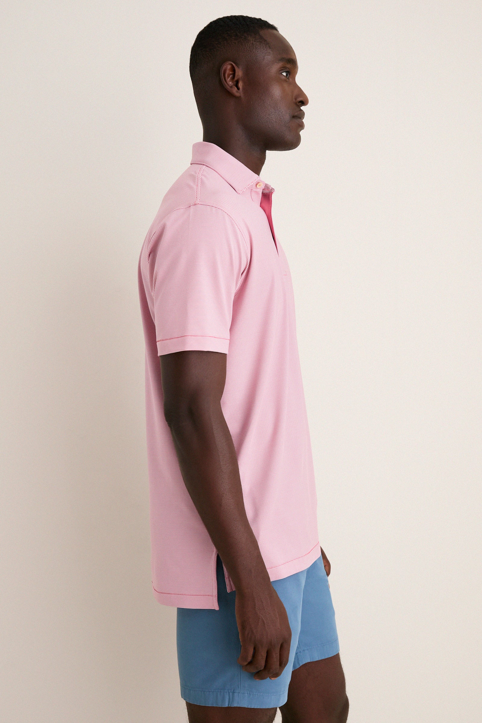 Man in Chili Red Jubilee Performance Jersey Polo, showcasing a classic, effortless, and high-end style with tailored fit and technical performance, perfect for a fun, casual look.