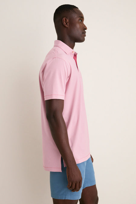 Man in Chili Red Jubilee Performance Jersey Polo, showcasing a classic, effortless, and high-end style with tailored fit and technical performance, perfect for a fun, casual look.