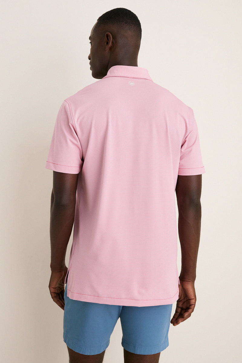 Back view of a man in a classic, light pink Chili Red Jubilee Performance Jersey Polo, showcasing effortless style and high-end design. The polo features short sleeves and a subtle back logo.