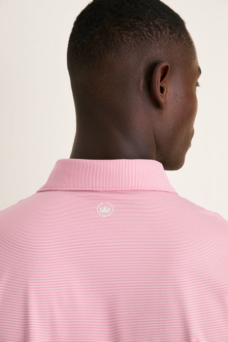 Back view of a man wearing the Chili Red Jubilee Performance Jersey Polo, showcasing its classic style with effortless, high-end details like a logo and comfortable fit.