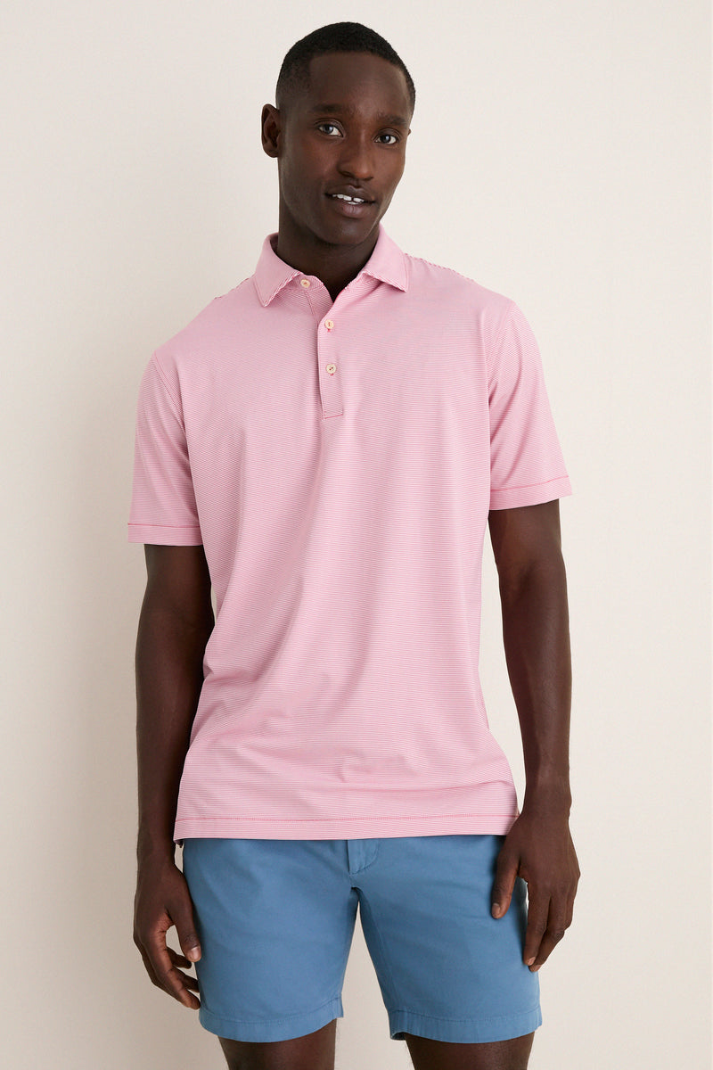 Man wearing the classic Chili Red Jubilee Performance Jersey Polo, featuring a tailored fit, short sleeves, and a two-button placket, epitomizing effortless, high-end style and fun mobility.