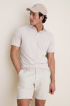 Male model in a classic, high-end Summer Dunes Stripe Albatross Cotton Blend Pique Polo, embodying effortless, fun style with tailored shorts and a baseball cap.