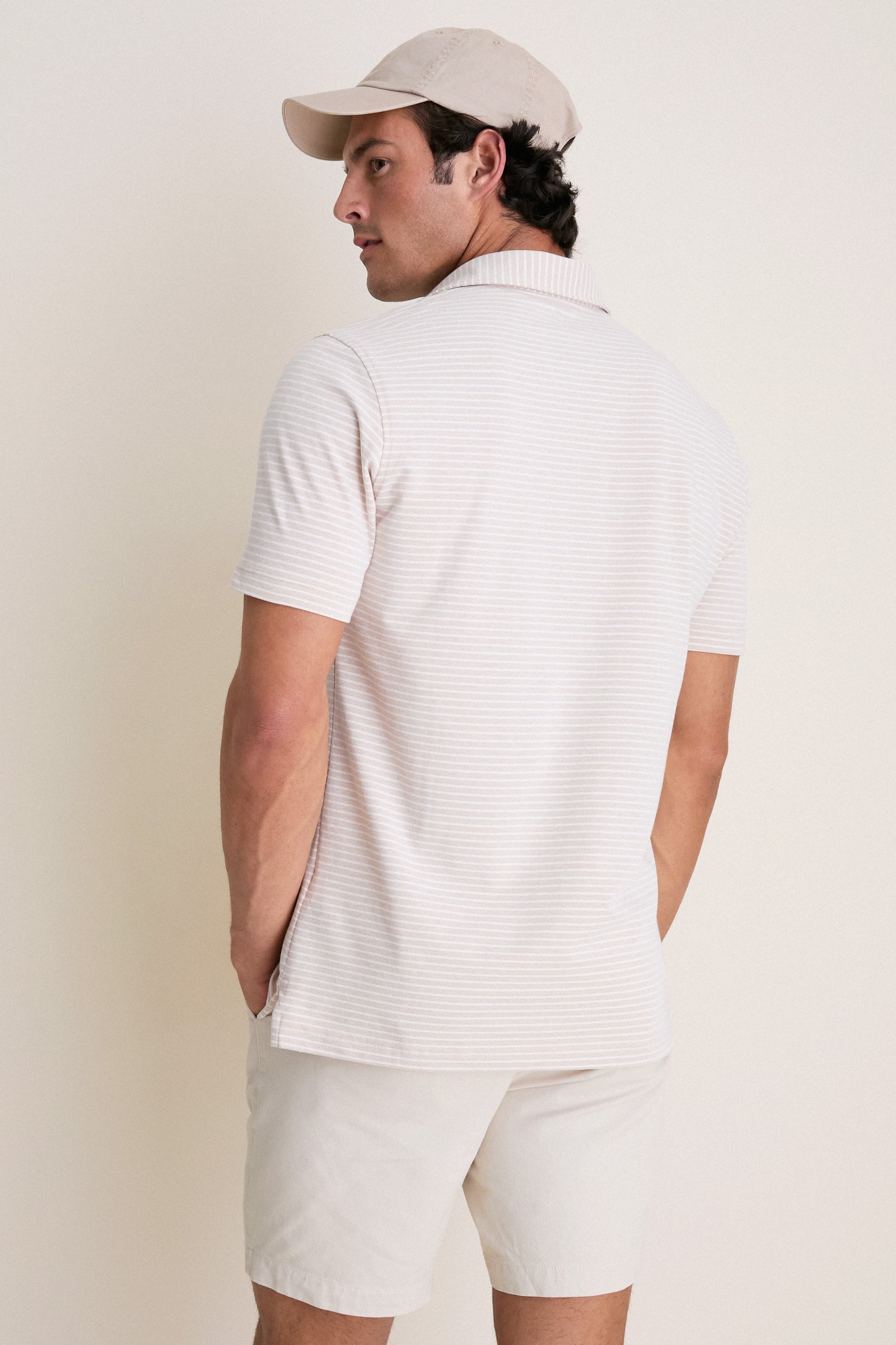Man wearing the Summer Dunes Stripe Albatross Cotton Blend Pique Polo, exemplifying classic, effortless style with high-end details like mother-of-pearl buttons and a reinforced spread collar.