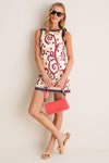 Model with Coral Brooks Crossbody—a classic, high-end red bag with beaded handle, exuding effortless style against a paisley dress, embodying fun and sophistication.