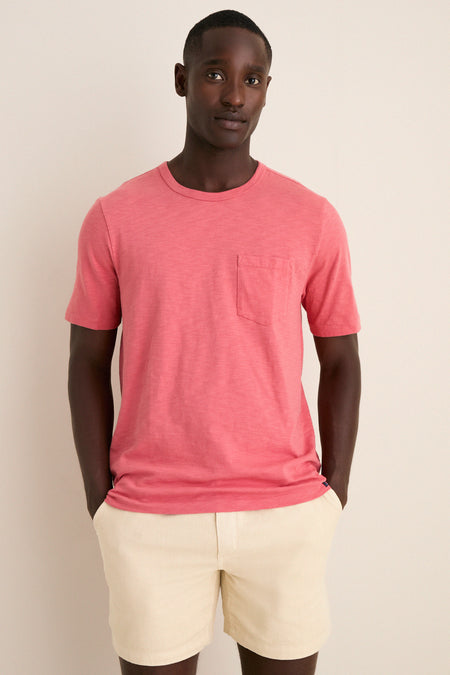 Young man wearing the Coral Red Sunwashed Pocket Tee, showcasing its classic, effortless style with a relaxed fit and fun, high-end design.