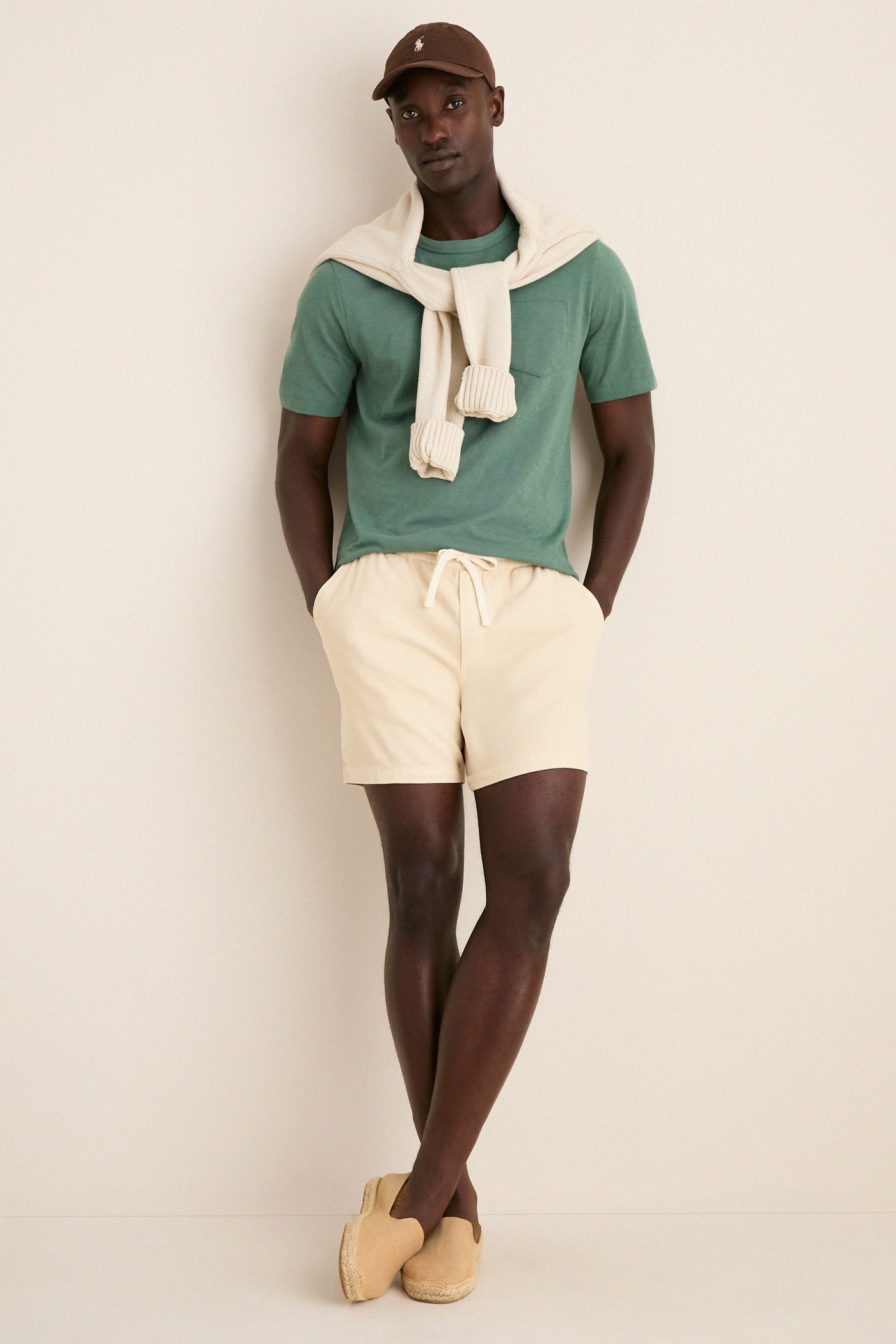 Young man in a classic, sunwashed tee and casual summer attire stands effortlessly, showcasing the high-end Island Spruce Sunwashed Pocket Tee with a relaxed, lived-in feel.