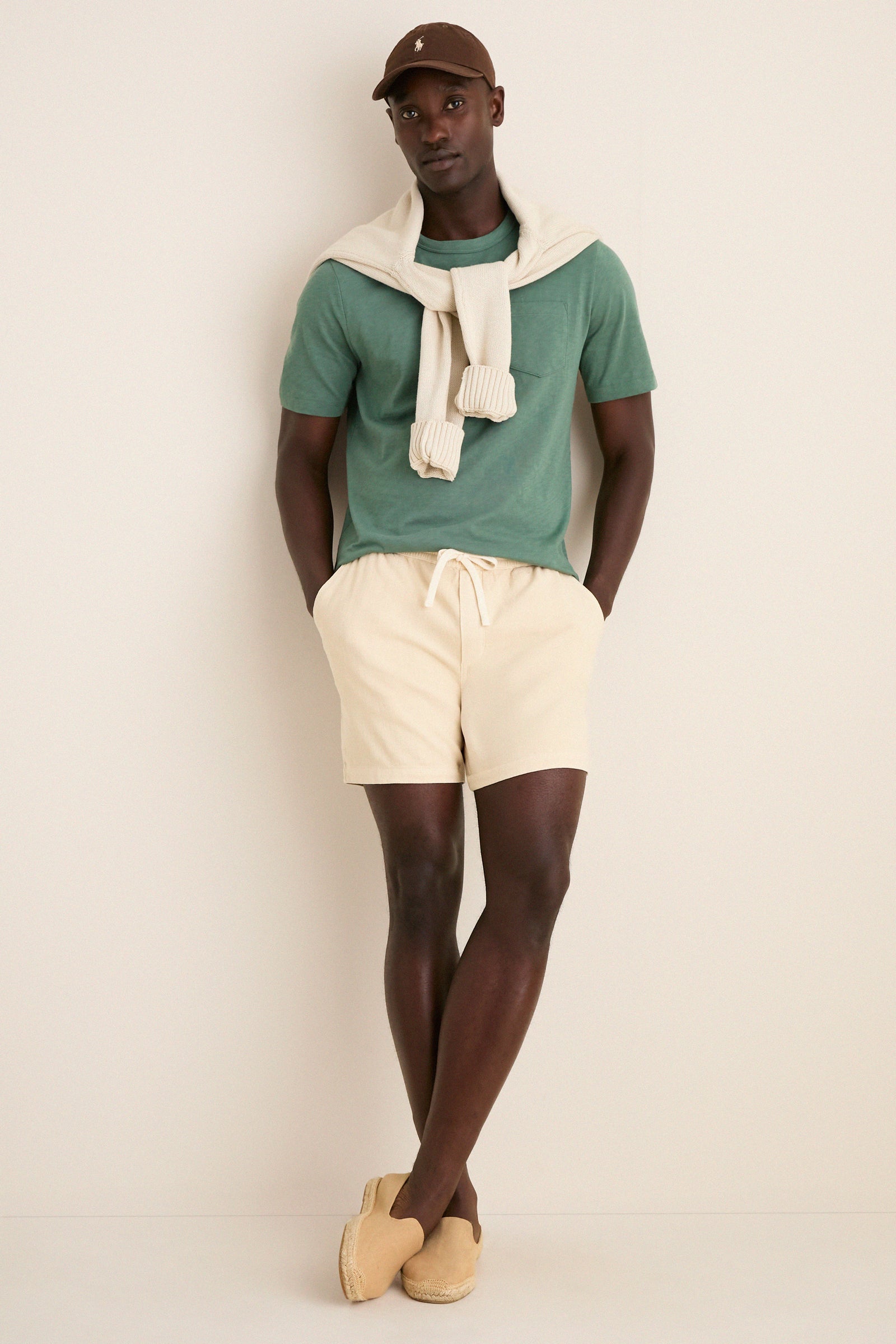 Young man in a classic, sunwashed tee and casual summer attire stands effortlessly, showcasing the high-end Island Spruce Sunwashed Pocket Tee with a relaxed, lived-in feel.