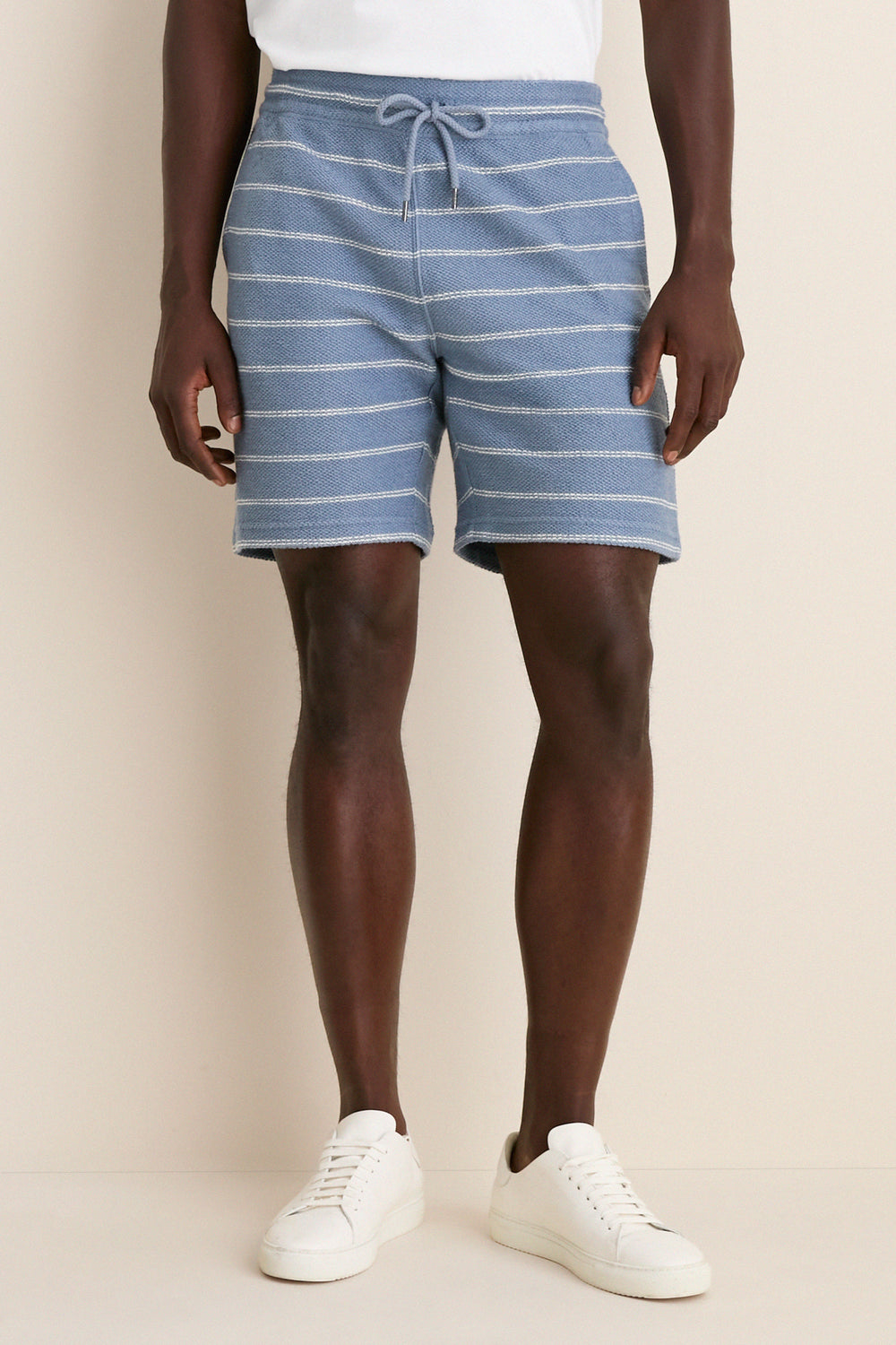 Model wearing Seabrook Stripe Whitewater Shorts with an elastic drawstring, exemplifying a classic, effortless, and fun style. Paired with white sneakers for a high-end, laid-back look.