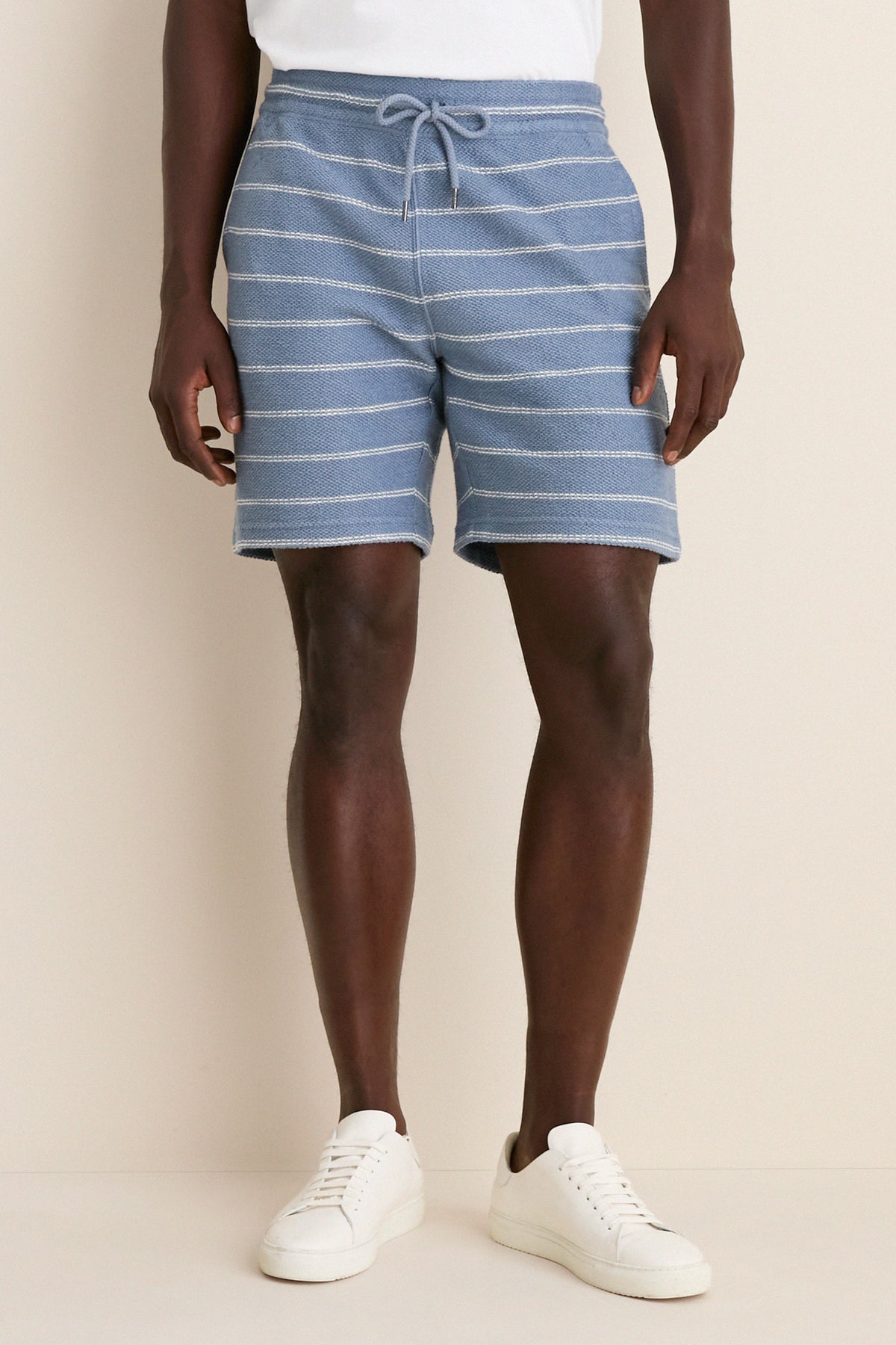 Model wearing Seabrook Stripe Whitewater Shorts with an elastic drawstring, exemplifying a classic, effortless, and fun style. Paired with white sneakers for a high-end, laid-back look.