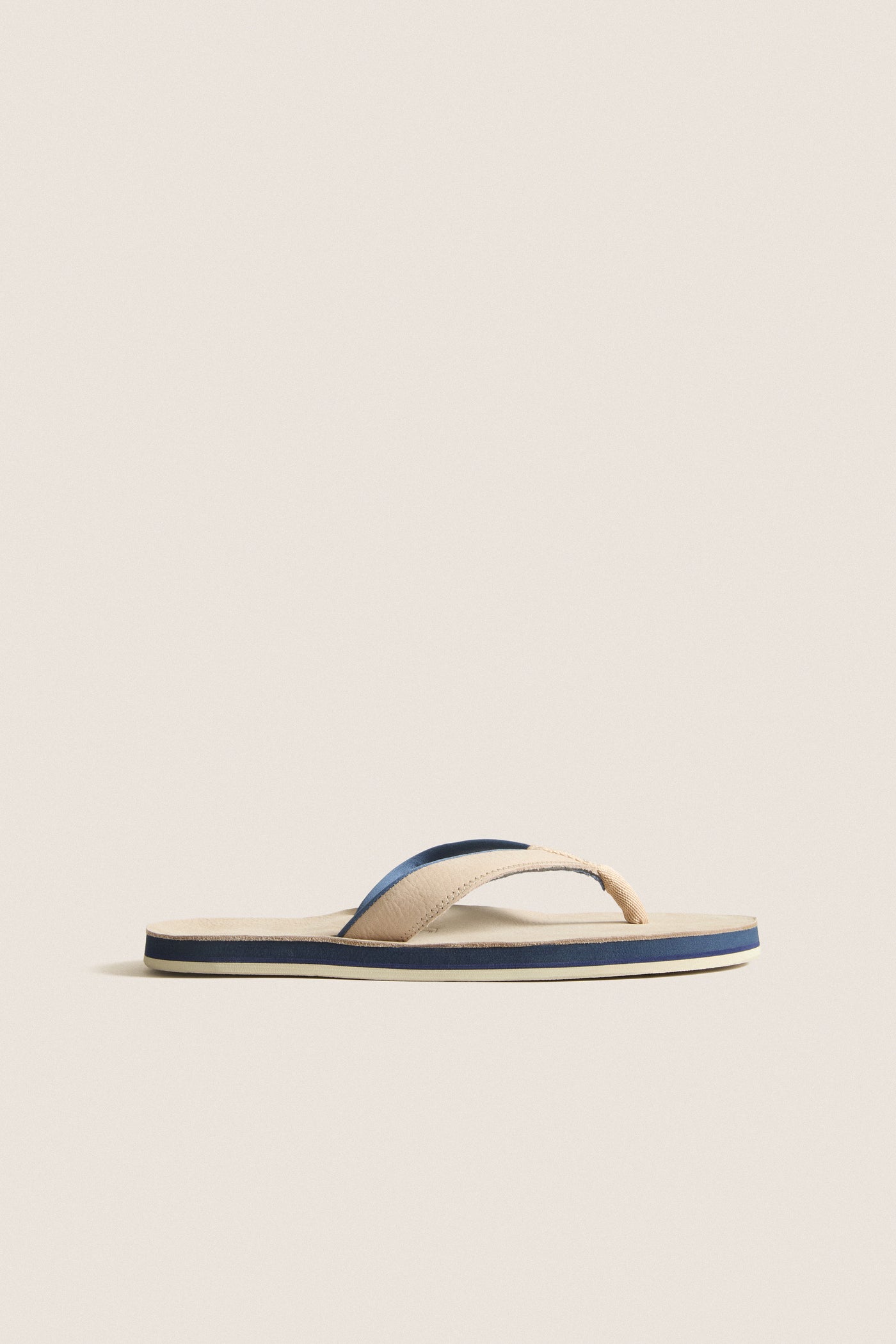 Classic Sand Pier Pebbled Leather Sandal with beige straps, navy and cream striped sole, offering effortless style and high-end comfort for fun, relaxed outings.