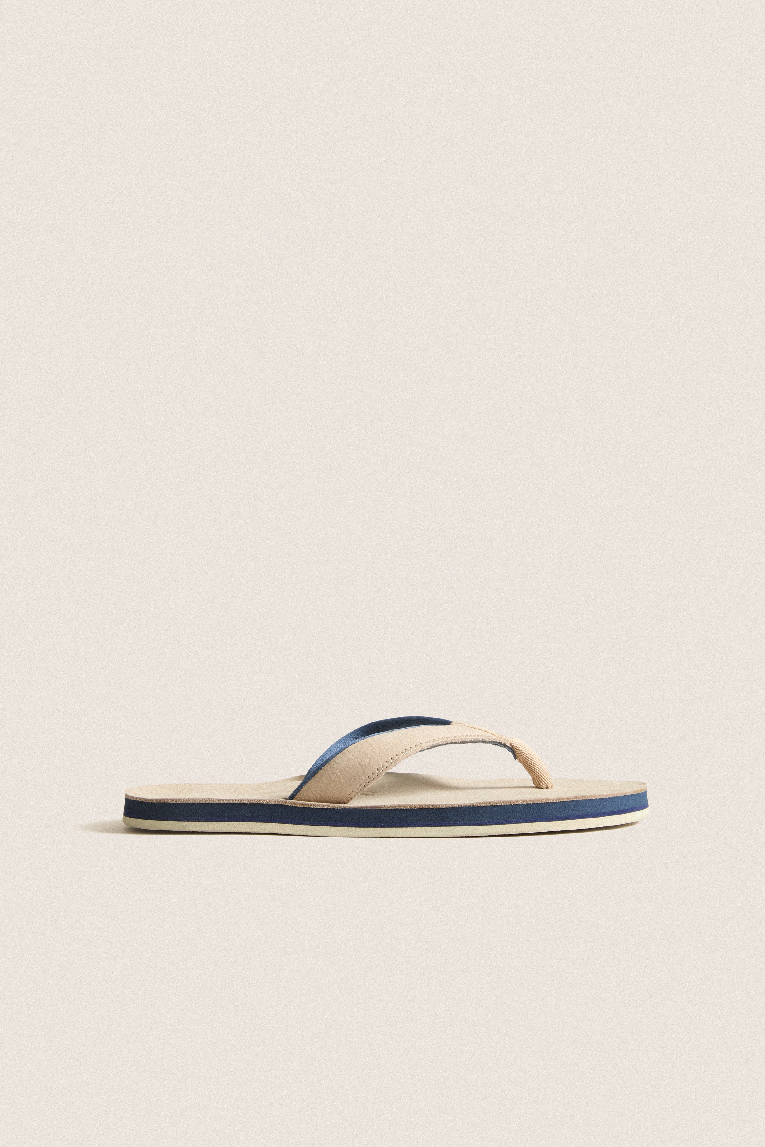 Classic Sand Pier Pebbled Leather Sandal with beige straps, navy and cream striped sole, offering effortless style and high-end comfort for fun, relaxed outings.