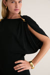 Woman wearing the classic Black Henderson Maxi Dress with an effortless one-shoulder design, featuring sculptural gold clips, a polished gold cuff, and hoop earring for a high-end look.