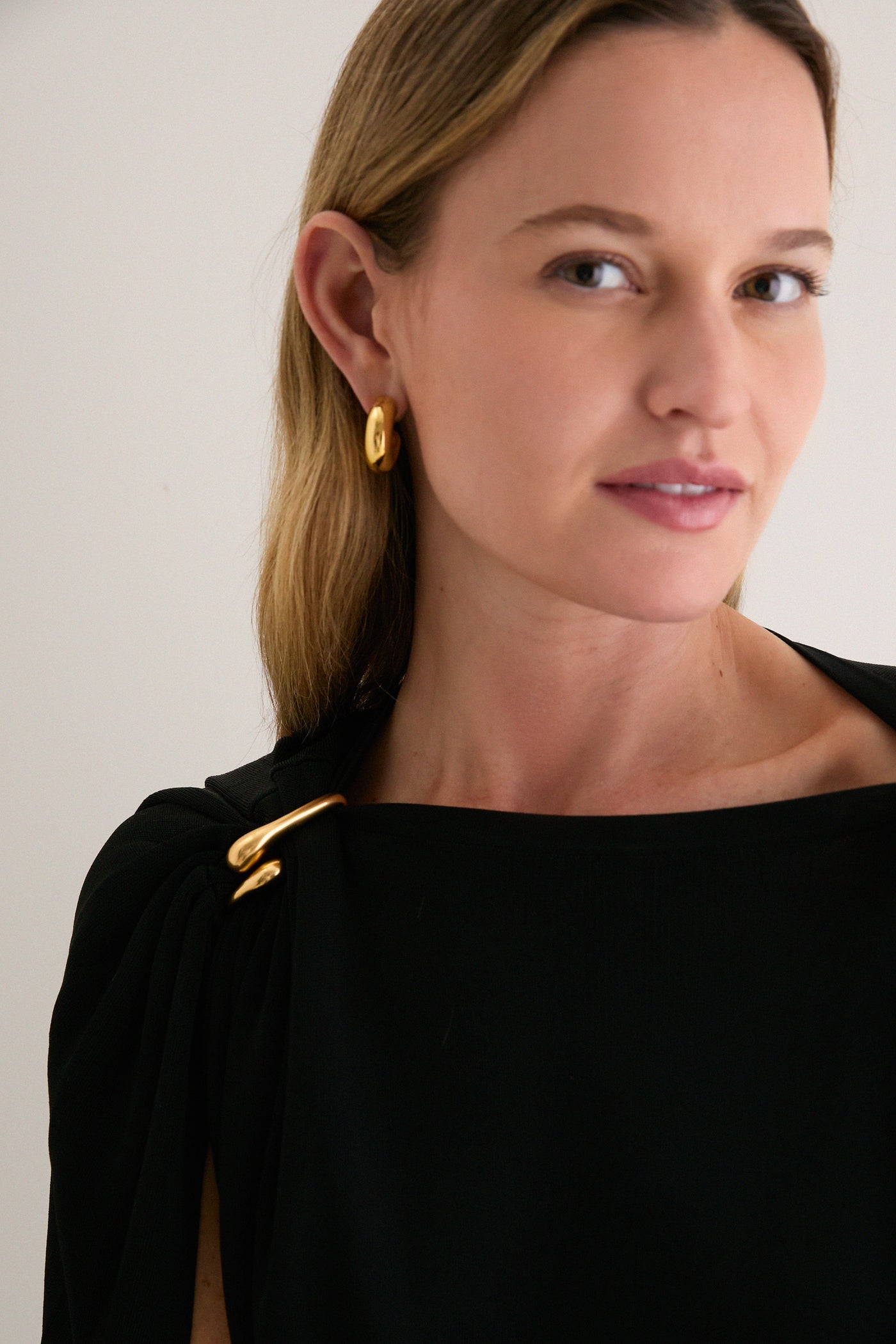 Woman wearing the Black Henderson Maxi Dress with a gold clasp detail, showcasing an effortless, classic look with a fun, high-end feel.