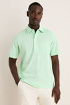 Young Black man wearing the classic Key West Oxford Pique Players Shirt, featuring a spread collar and chest flap pocket, paired effortlessly with trousers for a fun, high-end look.