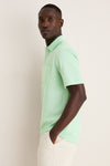 Young man in profile wearing the Key West Oxford Pique Players Shirt, a classic and effortless mint-green polo with a flap pocket, embodying a fun, high-end style.