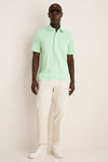 Man wearing the classic Key West Oxford Pique Players Shirt with flap pocket, styled effortlessly with trousers and a cap, embodying a fun, high-end look.