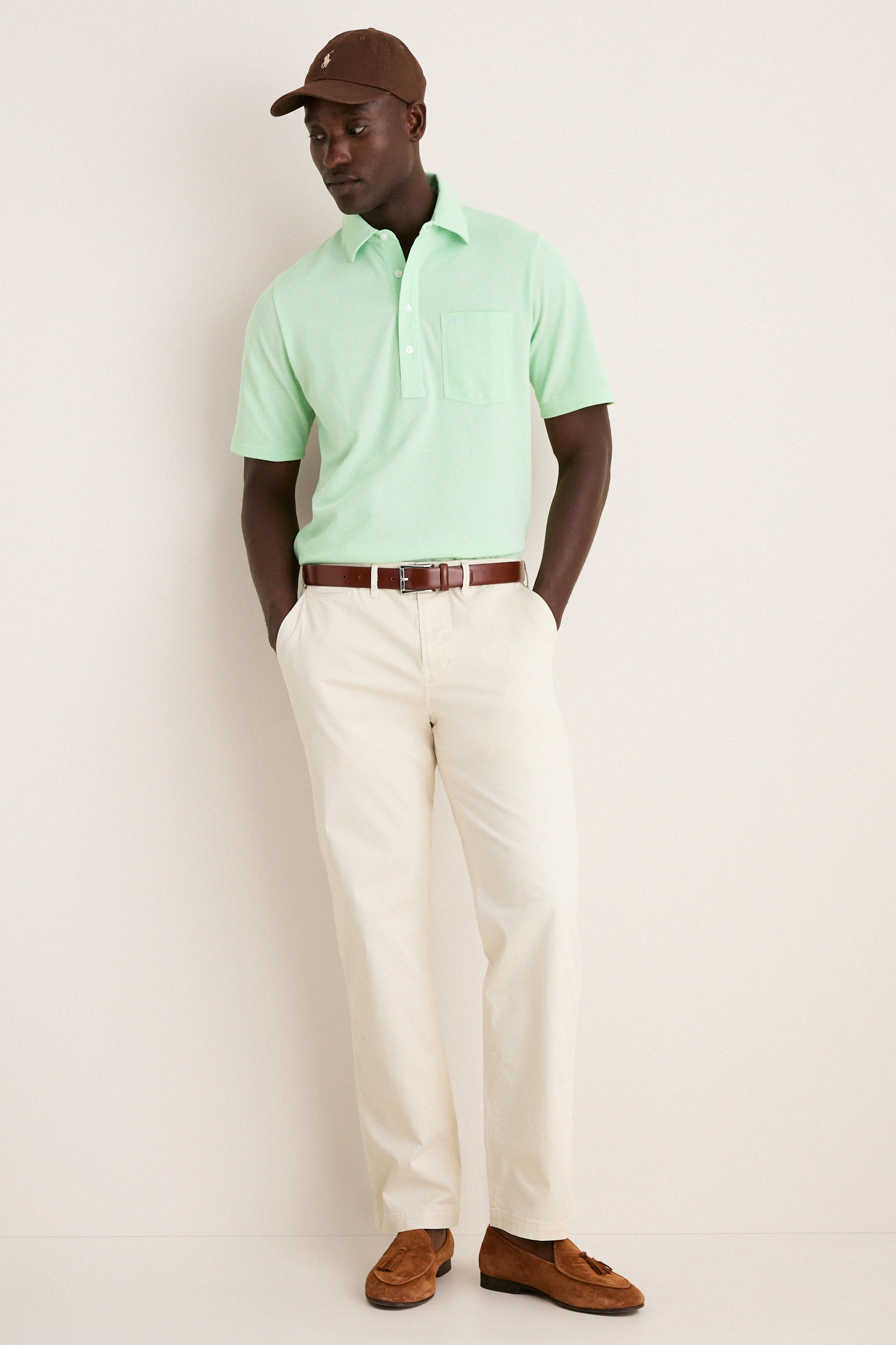 Man in a classic Key West Oxford Pique Players Shirt with chinos and loafers, embodying effortless style and fun, showcasing high-end casual elegance.