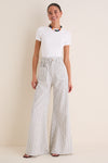 Young woman models the Juniper Stripe Linen Tulip Wide Leg Pant, showcasing its classic wide-leg, effortless fit, and fun coastal style with high-end appeal.