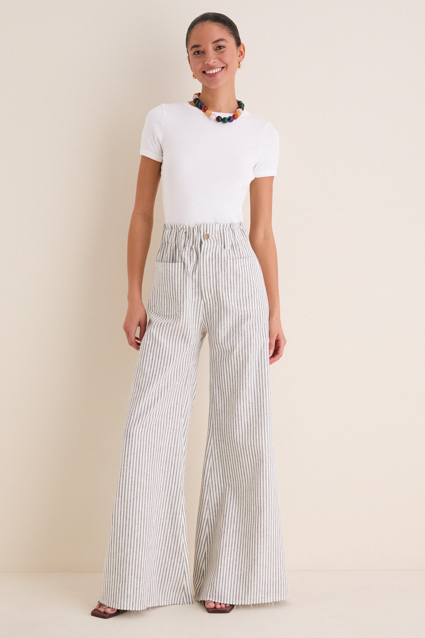 Young woman models the Juniper Stripe Linen Tulip Wide Leg Pant, showcasing its classic wide-leg, effortless fit, and fun coastal style with high-end appeal.