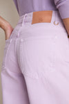 Close-up of the Wisteria Zephyr Mid Rise Wide Leg Jean, showcasing lavender denim, classic stitching, a tan brand patch, and a gold D-ring for effortless, high-end style.