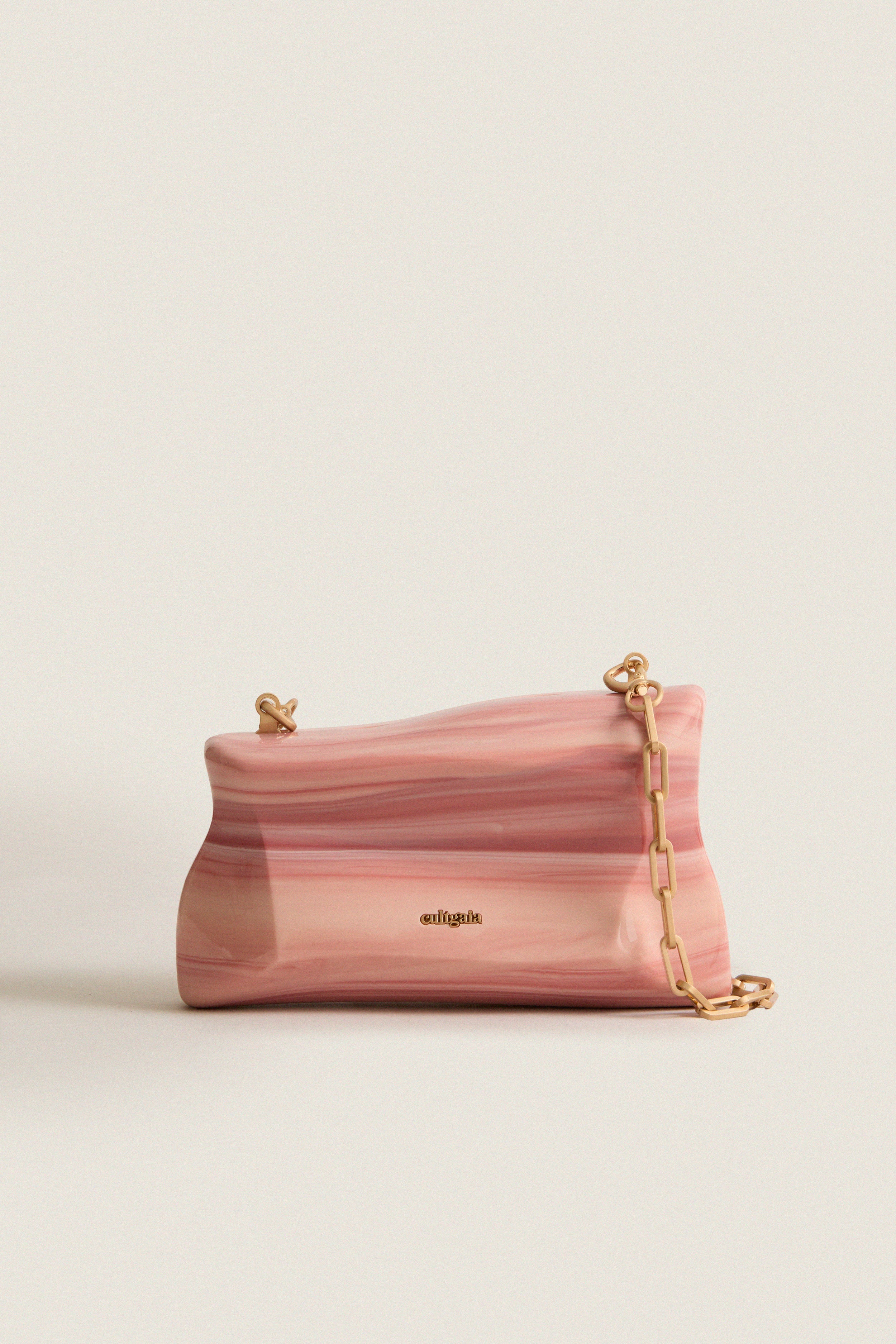 Rose Water Malaya Clutch: A classic, high-end piece with an effortless, fun vibe, featuring a marbled resin design, gold details, and a removable chain strap.