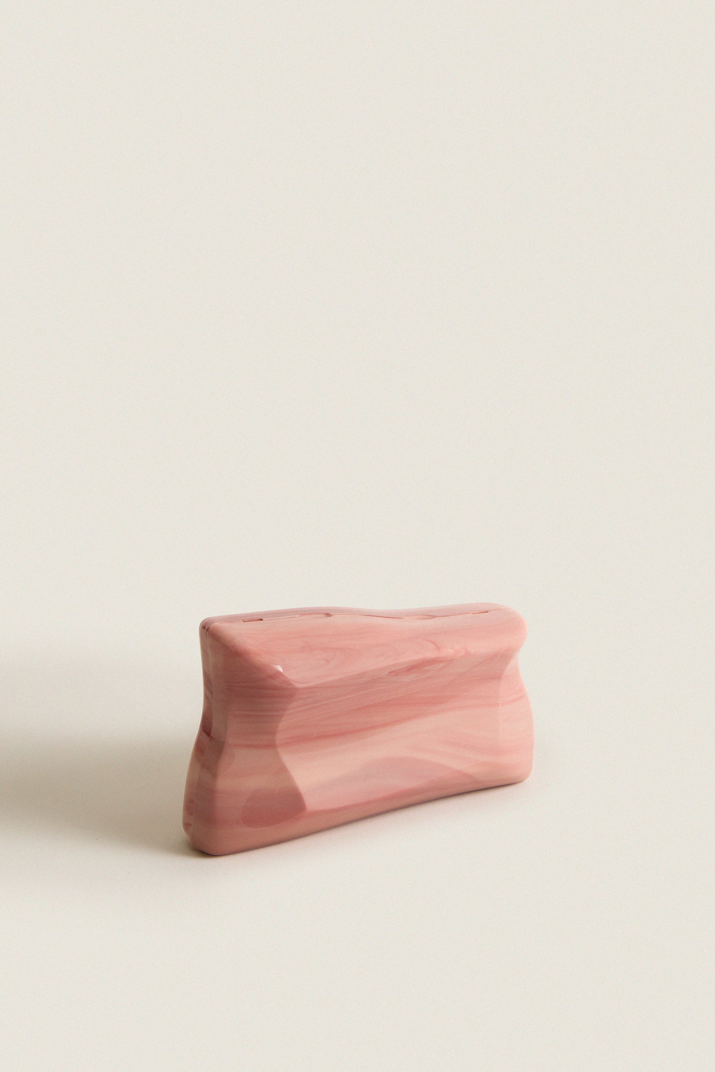 Rose Water Malaya Clutch, a classic, high-end marbled pink acrylic design with an abstract silhouette and removable chain strap, exudes effortless elegance and fun sophistication.