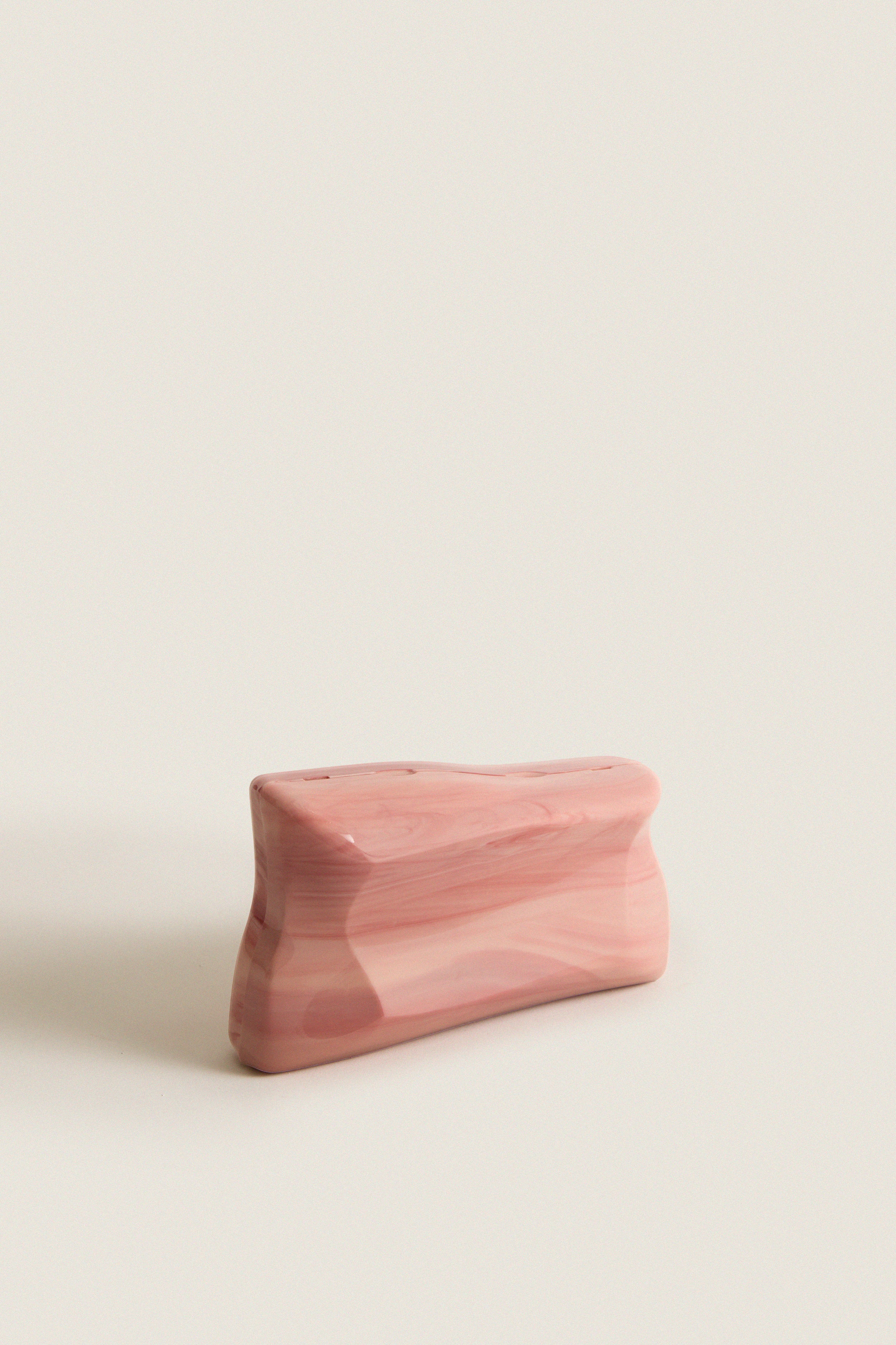 Rose Water Malaya Clutch, a classic, high-end marbled pink acrylic design with an abstract silhouette and removable chain strap, exudes effortless elegance and fun sophistication.